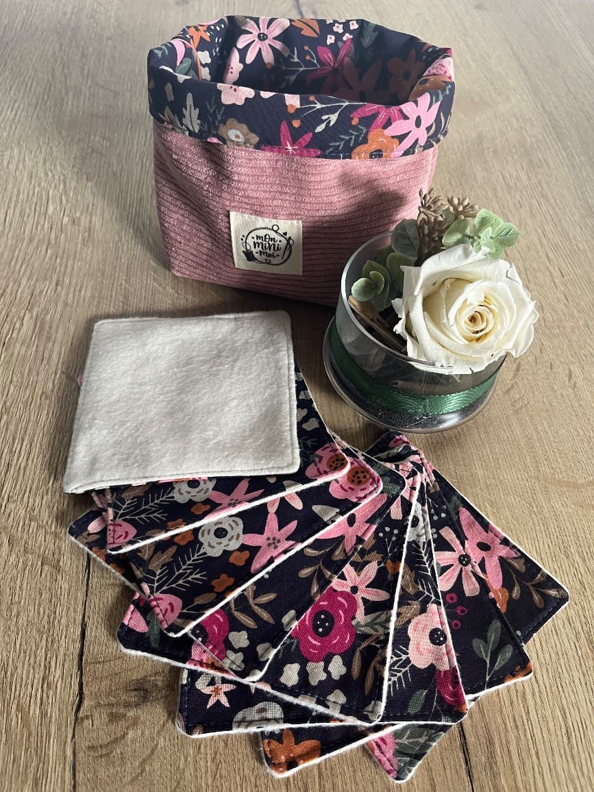 Panier souple rose côtelé à revers floral foncé, accompagné de lingettes assorties posées sur une table en bois.