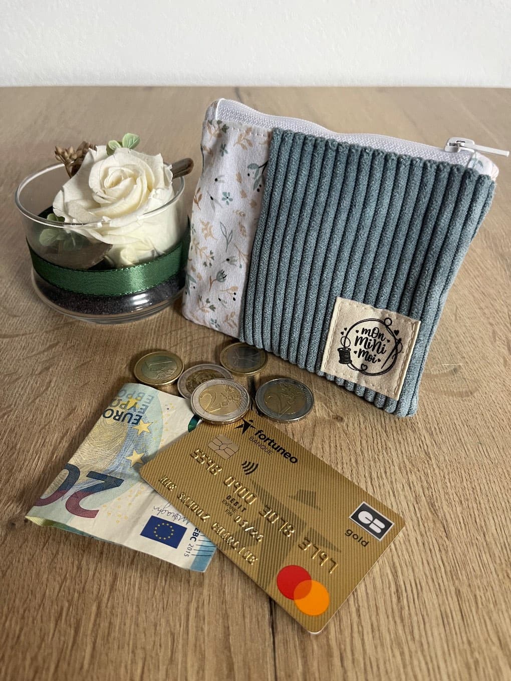 Porte-monnaie zippé bicolore en velours côtelé bleu et tissu clair fleuri avec étiquette cousue.