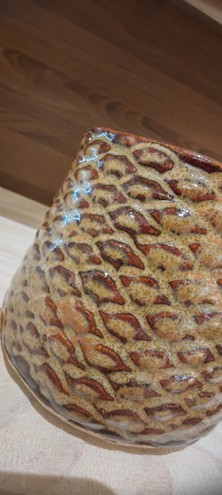 Vue de profil de la tasse texturée aux reflets ocre et marron avec sa grande anse.