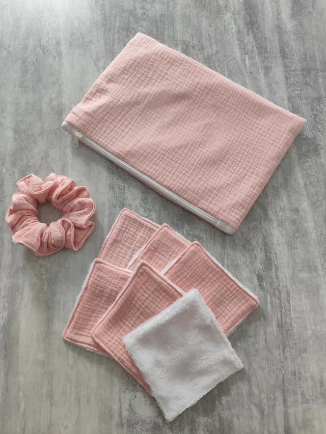 Kit rose avec pochette zippée, chouchou assorti et lingettes carrées lavables roses et blanches à plat.