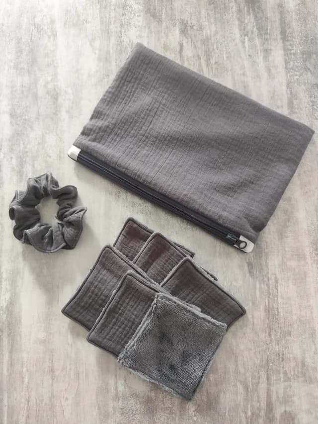 Ensemble artisanal gris comprenant une pochette zippée, six lingettes lavables et un chouchou assorti.