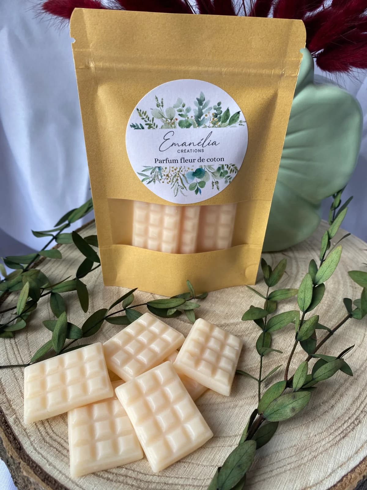 Plan rapproché des fondants parfumés blanc crème façon tablettes disposés devant le sachet kraft étiqueté.